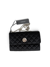 Load image into Gallery viewer, A black quilted Versace wallet with a silver-tone chain strap and a black hangtag, displayed on a clean white background.