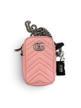 Load image into Gallery viewer, A pink chevron-quilted crossbody bag with a silver-tone interlocking G logo, a silver and black chain strap, and a black hangtag that reads 'GUSTOWN LUXE'.
