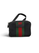 Load image into Gallery viewer, A black canvas cosmetic pouch with a green and red web stripe on the front, featuring a top handle and a small leather brand plaque.
